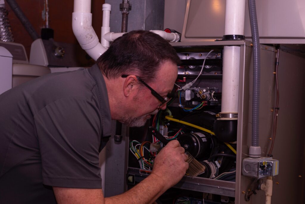 a man looking at a heating system repair